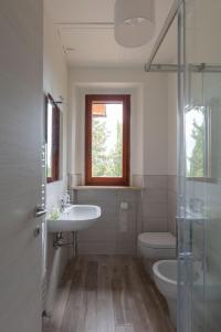 łazienka z umywalką, toaletą i oknem w obiekcie Casalchino-Fattoria La Torre w mieście San Gimignano +28 zdjęć