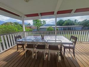 a table and chairs on a deck on a porch at Pitate Surf House in Atimaono