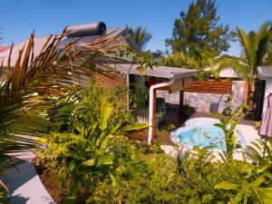 a garden with a swimming pool and a house at Bungalow Citronnelle in Saint-Pierre