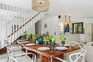 a dining room with a wooden table and white chairs at Magnifique Villa, 1H de Paris, Piscine chauffée ! in Labosse