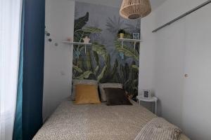 a bedroom with a bed with a plant mural on the wall at Cosy Oasis - T3 - Grande terrasse collective in Lourdes