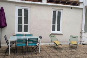 a table and four chairs and a table and a building at Cosy Oasis - T3 - Grande terrasse collective in Lourdes
