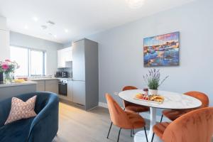eine Küche und ein Wohnzimmer mit Tisch und Stühlen in der Unterkunft Elliot Oliver - Cosy 2 Bedroom Town Centre Apartment in Cheltenham