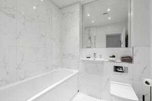 ein weißes Badezimmer mit Badewanne und Waschbecken in der Unterkunft Elliot Oliver - Cosy 2 Bedroom Town Centre Apartment in Cheltenham