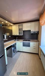 una grande cucina con armadi bianchi e lavastoviglie di проспект Мира 35 Апартаменты a Kryvyj Rih