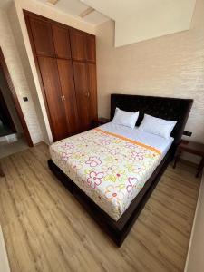 Douar Oulad HamoudaにあるAppartement à 10 min de la plageのベッドルーム1室(ベッド1台、木製キャビネット付)
