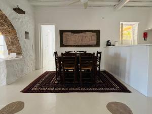 a dining room with a table and chairs on a rug at Stone Built Villa Ferretti in Plintri