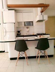 two green chairs in a kitchen with white cabinets at Confortable apto tipo Suite/ Turismo Relax in Caracas +18 photos