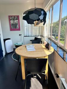 a room with a wooden table with chairs and a lamp at SWEETS - Gerben Wagenaarbrug in Amsterdam