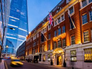 a building with flags on the side of a street at London Bridge Hotel in London