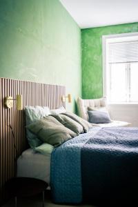 a bedroom with a bed with green walls and a window at Spacious Green Apartment With Amazing Loft in Copenhagen