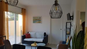 un soggiorno con un divano e sedie blu di Coquette maison canetoise a Canet-en-Roussillon