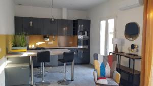 una cucina con armadi neri e sgabelli da bar di Coquette maison canetoise a Canet-en-Roussillon