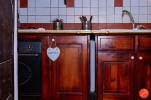 una cocina con armarios de madera y un fregadero con una etiqueta en Gorgeous House Trastevere, en Roma