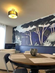 Una habitación con una mesa y un cuadro grande en la pared. en La Lorraine : cosy en centre ville, en Poitiers