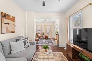 sala de estar con sofá gris y TV de pantalla plana en Charming Home in Cleveland 3215, en Ohio City