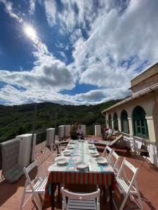 a long table on the roof of a house at Villa Massa - Dimora storica con 12 camere, accoglie 30 persone in Calice Ligure