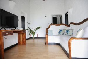 a bedroom with a large bed and a tv at The Salty Palms in Beau Vallon