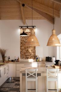 a kitchen with two pendant lights and a stone wall at Casa Pompilio in Sagres