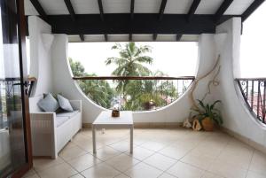 a living room with a couch and a large window at The Salty Palms in Beau Vallon