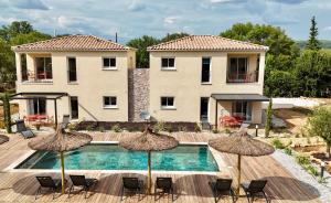 a villa with a swimming pool with chairs and umbrellas at Le Clos de L'Oliveraie - Appartements de charme avec piscine proche d'Uzès in Sagriès
