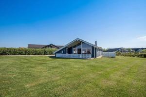 a small blue house on a grass field at 4 bedrooms and a beautiful view in Vinderup