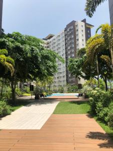 a walkway in a park with a large building at Majestic One Bedroom Condo Unit in Iloilo City