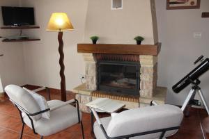 Una sala de estar con dos sillas y una chimenea. en La Casita de Ana, en Puntagorda
