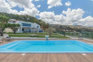 a swimming pool with a view of a house at Thea Villa Santa Marina in Malia