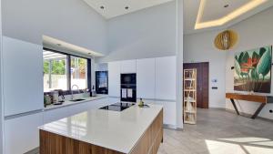 eine Küche mit weißen Wänden und einer weißen Arbeitsplatte in der Unterkunft Villa Estrelícia by LovelyStay in Ribeira Brava