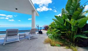 eine Terrasse mit 2 Stühlen und Meerblick in der Unterkunft Villa Estrelícia by LovelyStay in Ribeira Brava