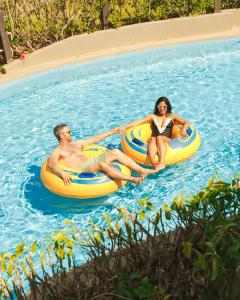 プンタ・カナにあるHard Rock Hotel & Casino Punta Cana - All Inclusiveのプールで2つのチューブに乗っている男性と女性