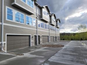 a large apartment building with a garage at The HoneyBee at Coventry Rows in Omaha