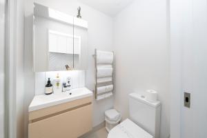 a white bathroom with a sink and a toilet at CBD beautiful studio Union street in Auckland +4 photos