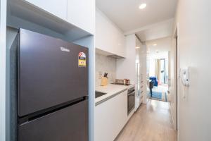 a kitchen with a stainless steel refrigerator and a hallway at CBD beautiful studio Union street in Auckland