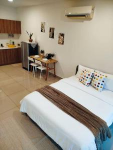 a bedroom with a large bed and a table at Cozy Haven Superior Studio Free Private Parking Netflix in Petaling Jaya