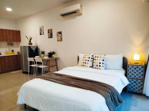 a bedroom with a large bed and a kitchen at Cozy Haven Superior Studio Free Private Parking Netflix in Petaling Jaya