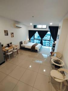 a bedroom with a bed and a table and chairs at Cozy Haven Superior Studio Free Private Parking Netflix in Petaling Jaya +4 photos