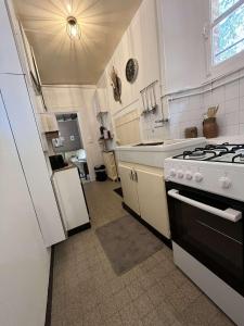 a white kitchen with a stove and a sink at L' otentic in Conie-Molitard