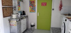 Una pequeña cocina con una puerta verde en una habitación. en Croix Montoire, en Tours