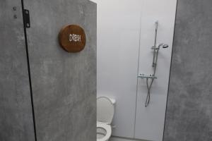 a bathroom with a toilet and a sign on the wall at Dreish - Glamping Pod in Forfar
