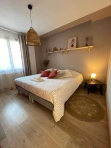 une chambre avec un lit avec des oreillers dessus dans l'établissement La P'tite Ambrièroise, à Ambrières 15 autres photos