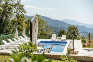a pool with chairs and umbrellas in a resort at Villa Goranovic in Herceg-Novi