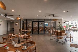 a restaurant with wooden tables and chairs and windows at Wyndham Garden Mazatlan Marina in Mazatlán