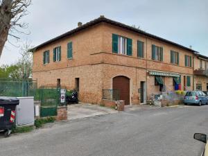 un edificio in mattoni con un'auto parcheggiata di fronte di Ciclamino fori Porta Pispini 2 a Siena