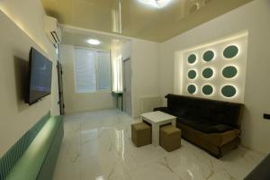 a living room with a couch and a tv at Apartment Pluse in Kutaisi