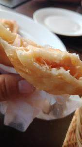 a person holding a hot dog with cheese and meat at departamentoplaya in Tomé