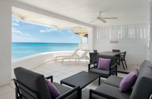 a patio with a table and chairs and the ocean at Purple Rain - Direct Seaviews, 2 Bedroom, 2 Bathroom, 3 Terrace Beachfront Bliss in Saint Peter