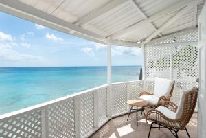 a balcony with chairs and a view of the ocean at Purple Rain - Direct Seaviews, 2 Bedroom, 2 Bathroom, 3 Terrace Beachfront Bliss in Saint Peter