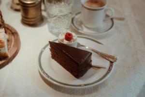 a piece of chocolate cake on a plate on a table at Pension Mühlbacherhof in Mühlbach am Hochkönig +55 photos